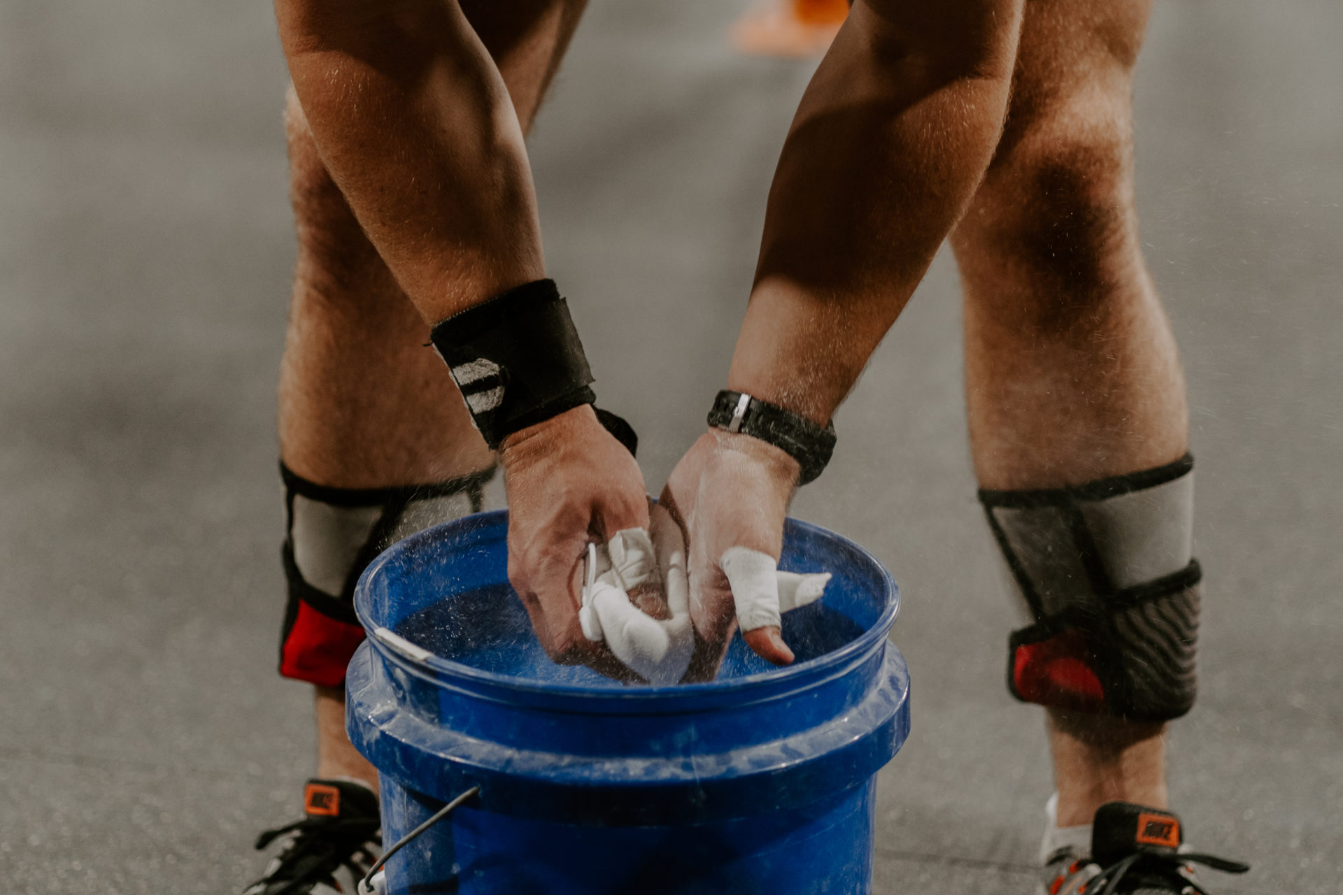 Close-up commercial photography of a man putting chalk on his hands before a workout.