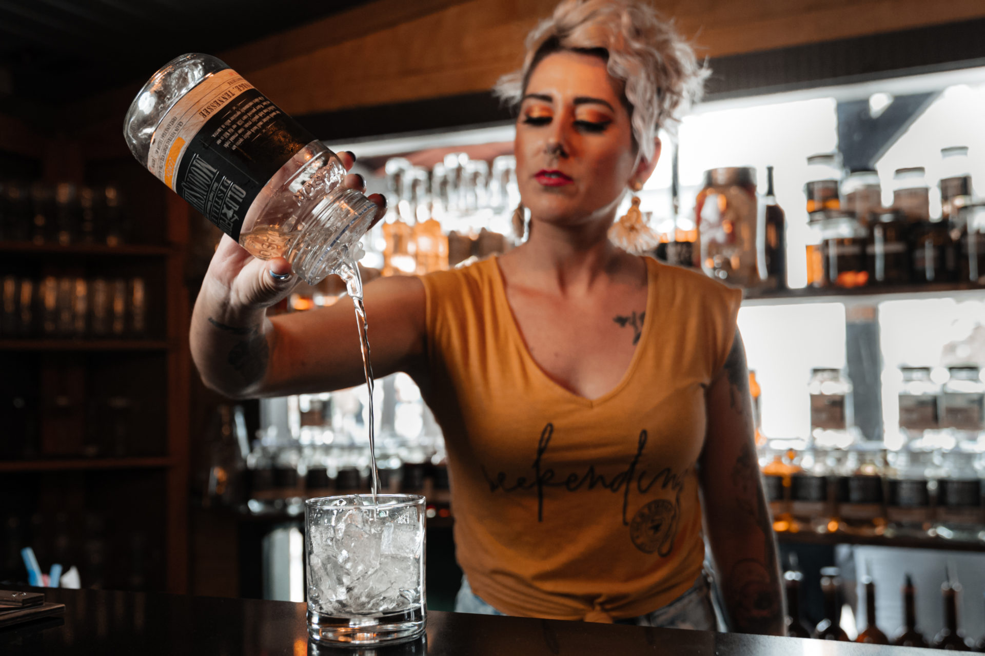 Product photography of a bartender pouring Old Forge Distillery moonshine into a cocktail glass.
