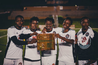 Austin East Men's soccer team holding their district champions plaque