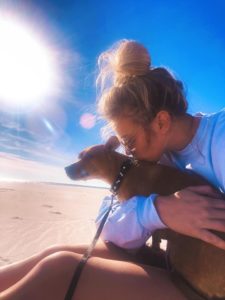 Taylor Mathews and her dog on the beach