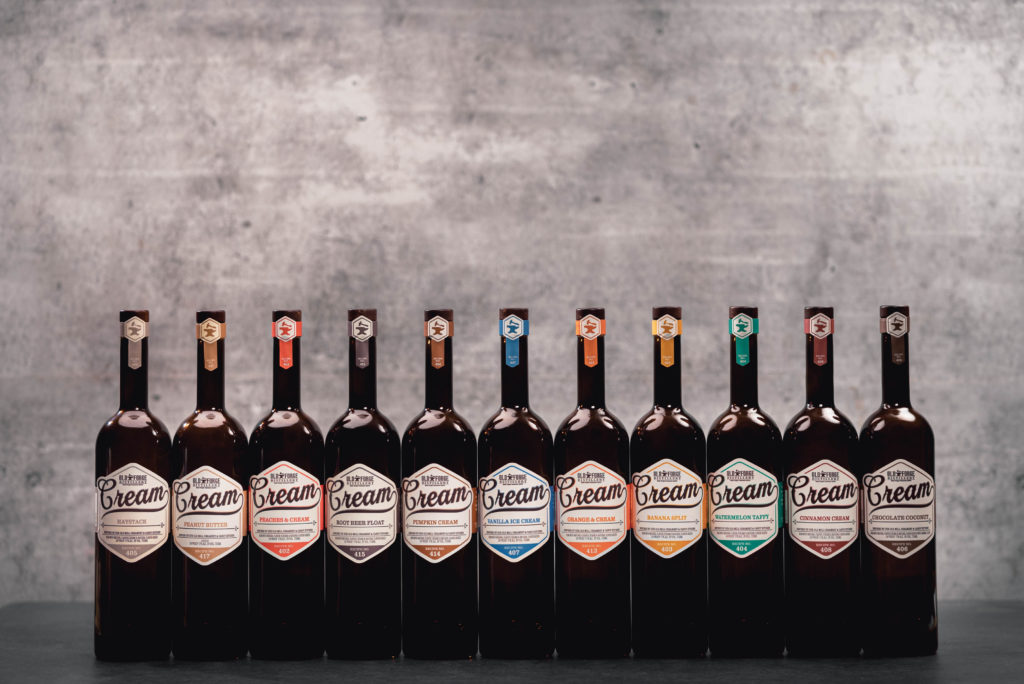 Commercial photography of Old Forge Cream rum bottles lined up with different flavors.