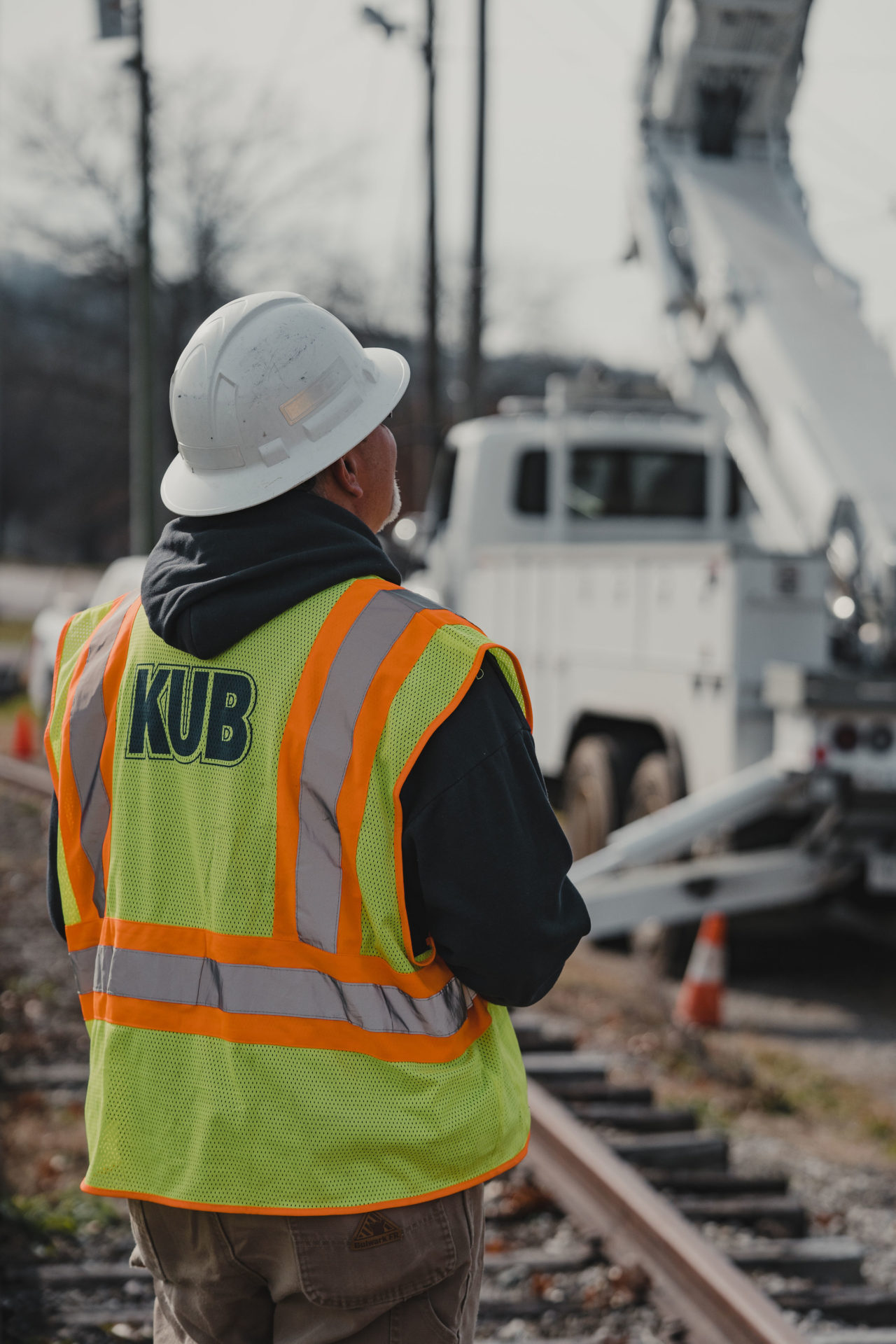 Lifestyle photography of a KUB employee looking up at machinery while standing on a Knoxville railroad.