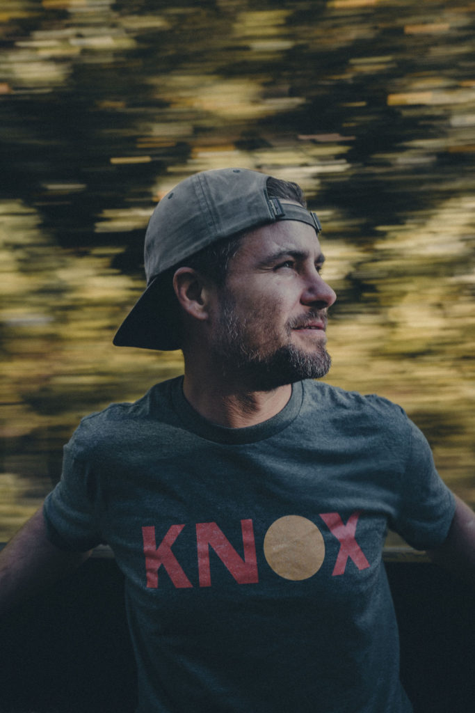 Lifestyle photography portrait of man in OneKnox shirt with East Tennessee forest background.
