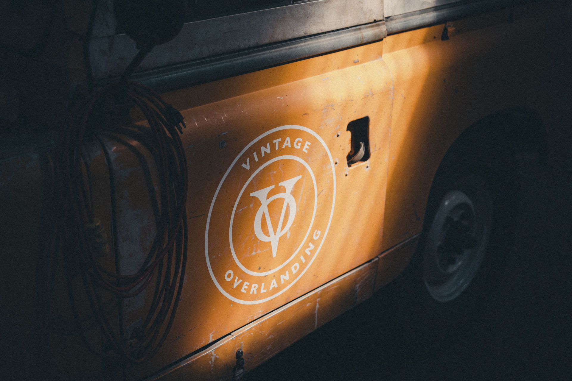 Close-up commercial photography of a Vintage Outfitting logo on the side of an orange Land Rover in Chattanooga, TN.