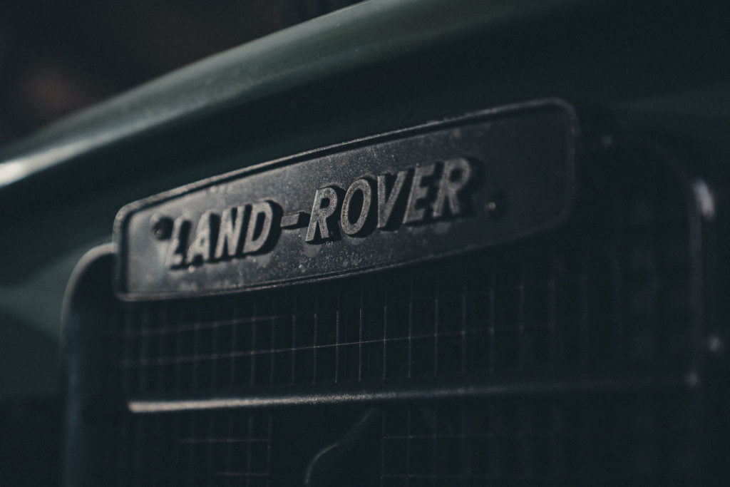 Close-up commercial photography of a Land-Rover logo on the front of a car.