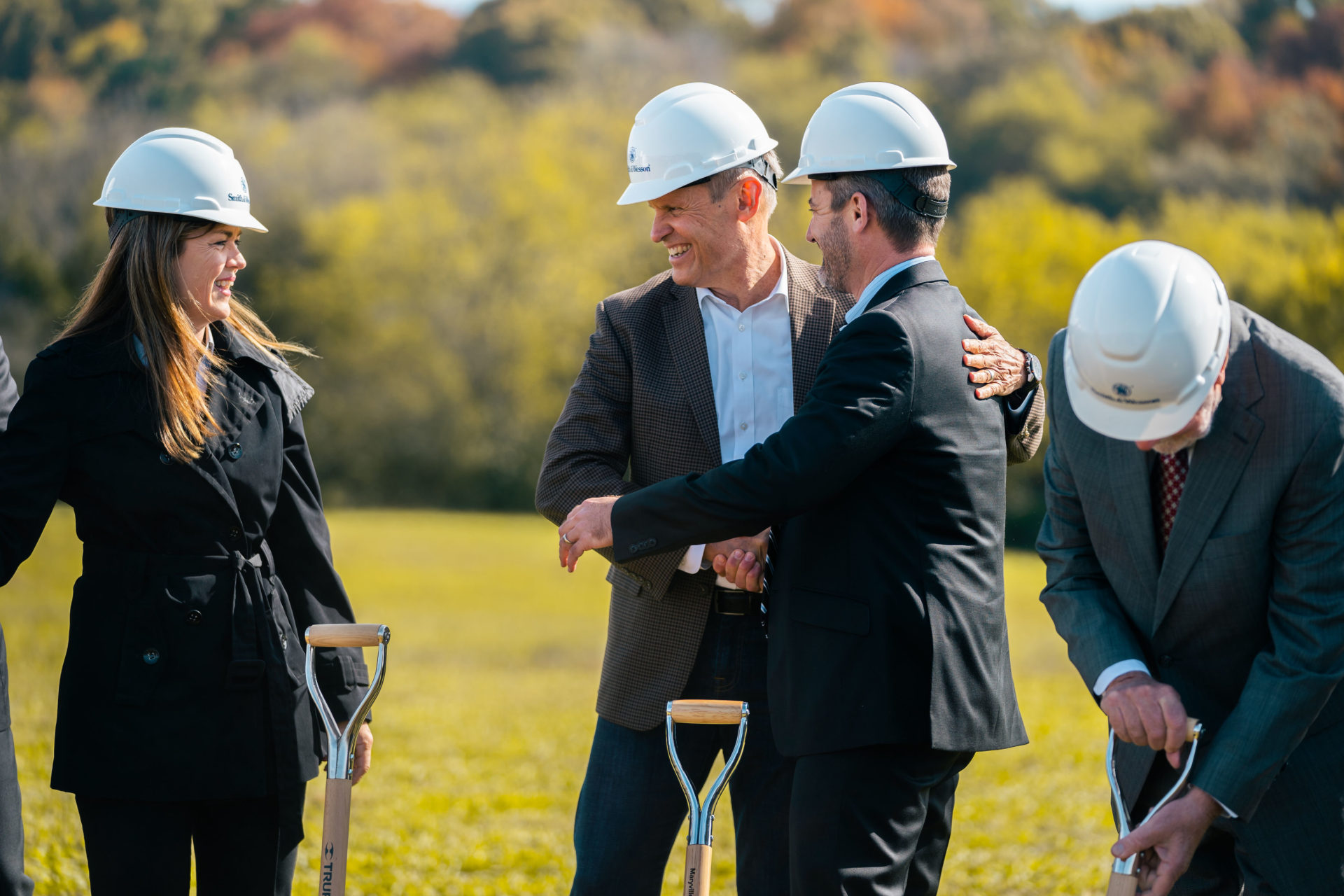 Event photography of four people wearing white helmets and conversing at a groundbreaking event in East TN.