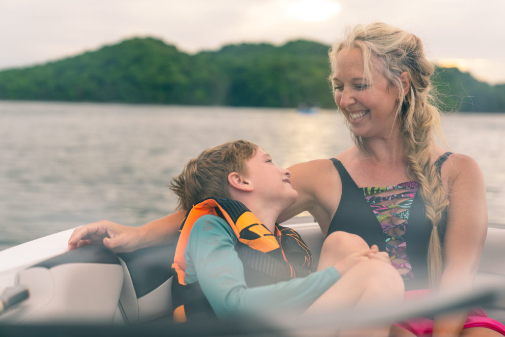 Lifestyle photography of a mother and son smiling on a boat in East Tennessee.