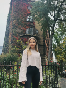 Olivia Neely in front of a vine-covered building