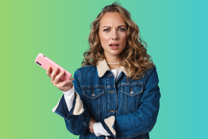 A woman looking annoyed holding her cell phone