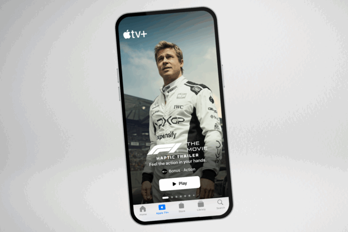 A phone shows the F1 haptic trailer on the Apple TV app.